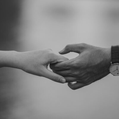 Monochrome image of two hands holding, symbolizing love and connection.